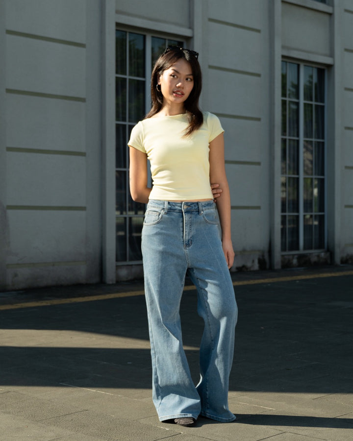 Daisy Yellow Padded Chic Baby Tee worn with blue jeans outdoors